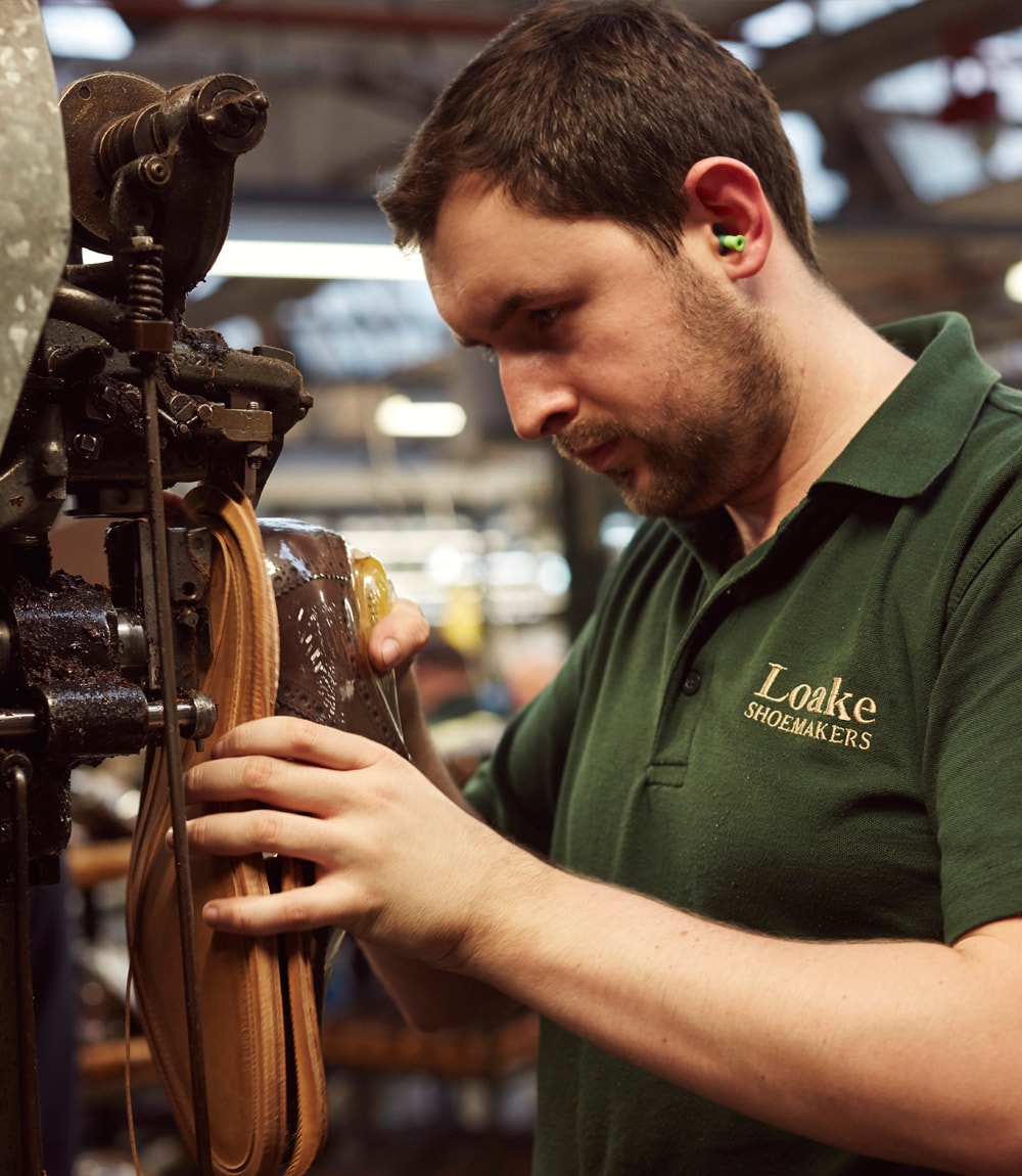 Loake craftsman, operating a welt trimming machine, creating a Loake heel and sole repair
