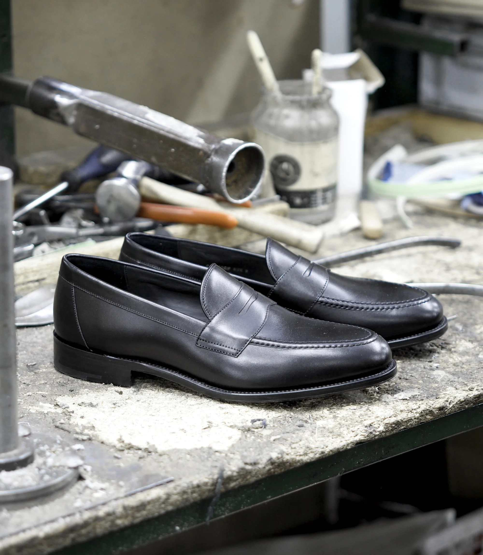 A single pair of Loake Hornbeam Loafer in Black placed on a factory worktop.