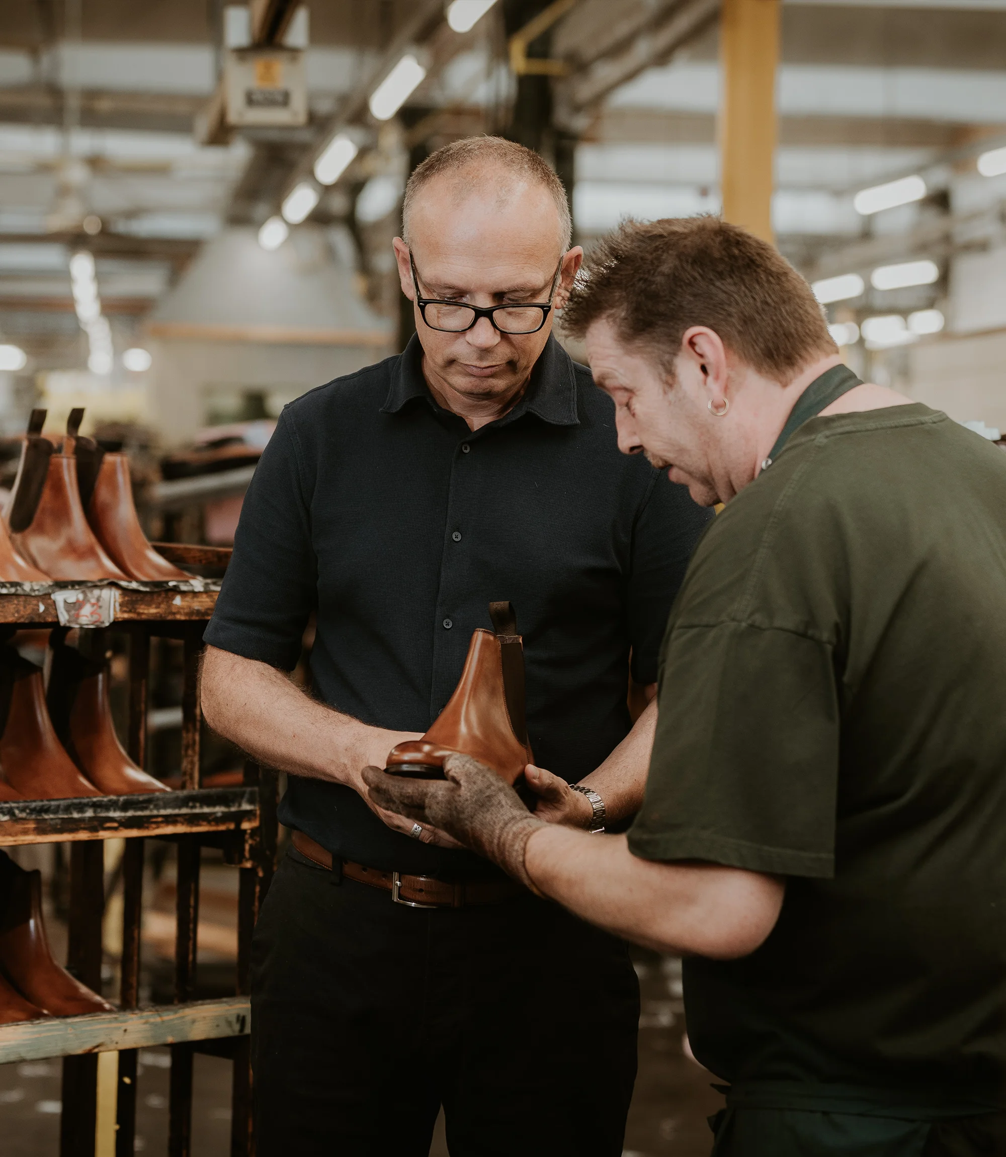Two master Loake craftsman, observing a Brown Chelsea Leather Boot that was handmade in Loake's English factoy ry